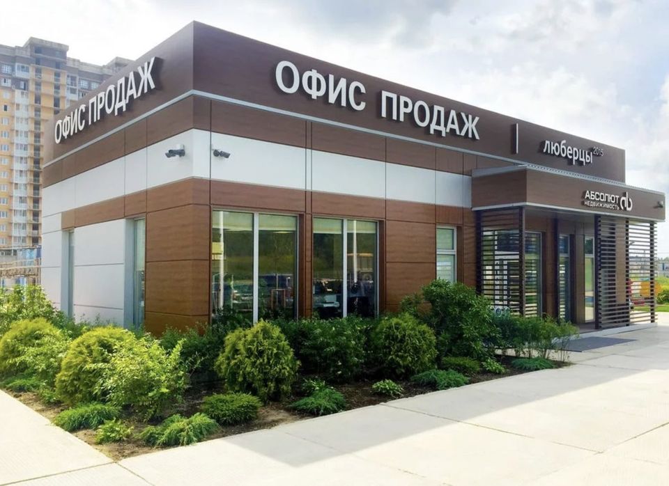 Офис продаж жилого комплекса с вывеской на фасаде